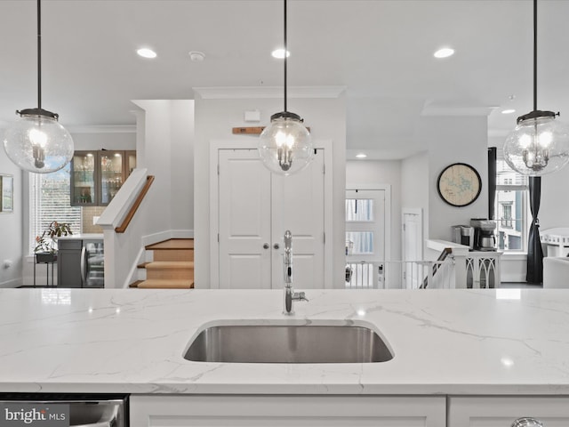 kitchen featuring white cabinets, sink, and pendant lighting