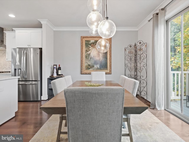 dining room with ornamental molding and dark hardwood / wood-style flooring