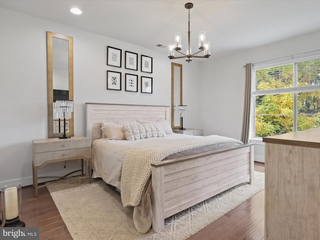 bedroom with a notable chandelier and dark hardwood / wood-style floors