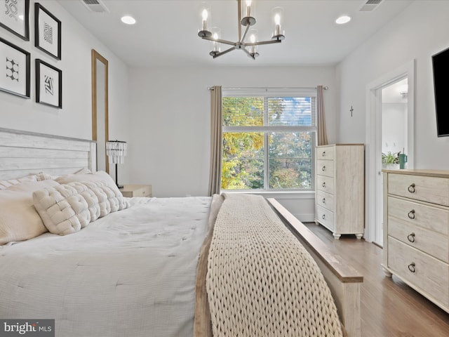 bedroom with an inviting chandelier and dark hardwood / wood-style flooring