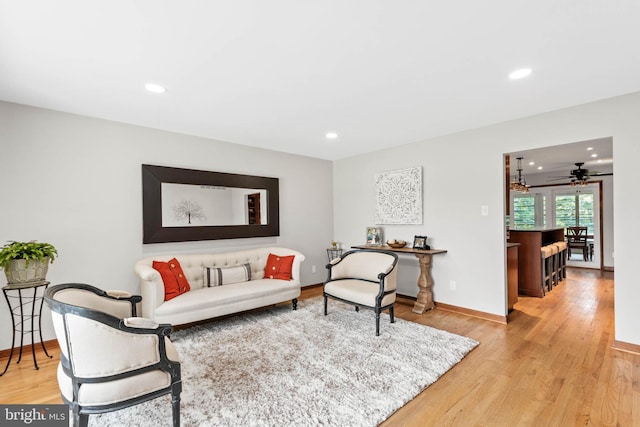 living room with light wood-type flooring and ceiling fan