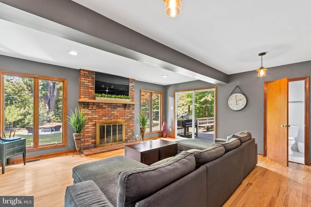 living room featuring light wood-type flooring and a brick fireplace