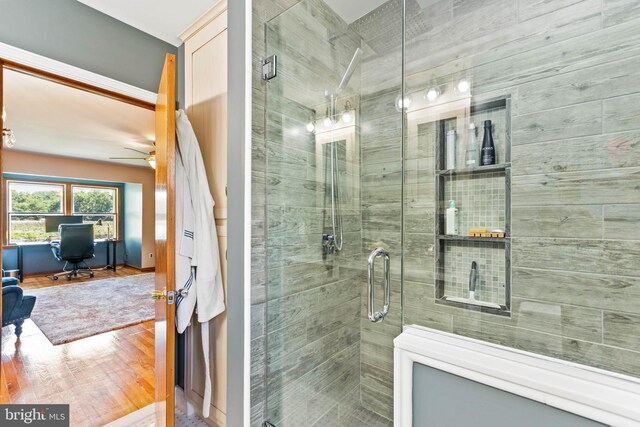 bathroom featuring ceiling fan, wood-type flooring, and walk in shower