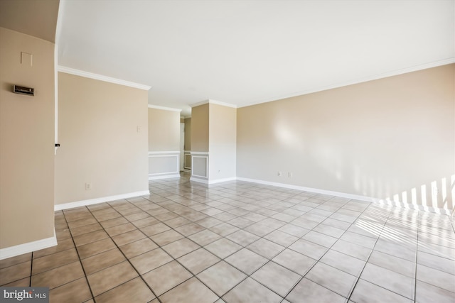 spare room featuring light tile patterned floors and crown molding