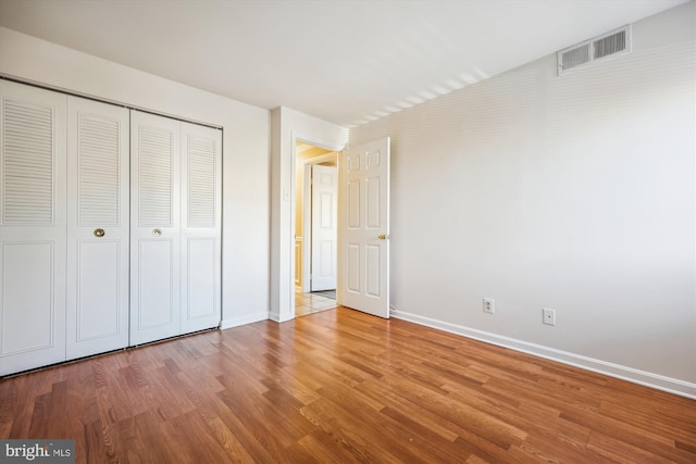 unfurnished bedroom with hardwood / wood-style floors and a closet