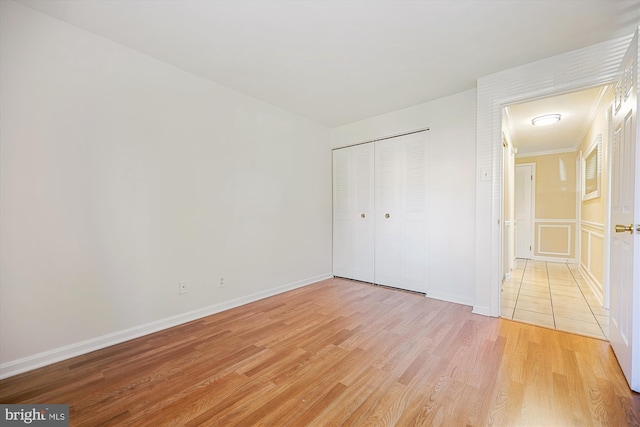 unfurnished bedroom featuring light wood-type flooring and a closet