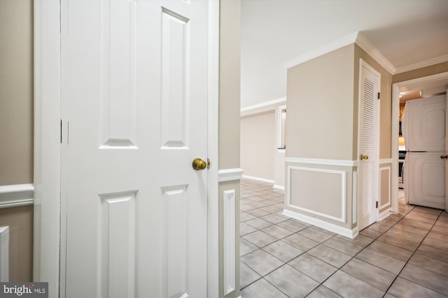 hall with light tile patterned floors and crown molding