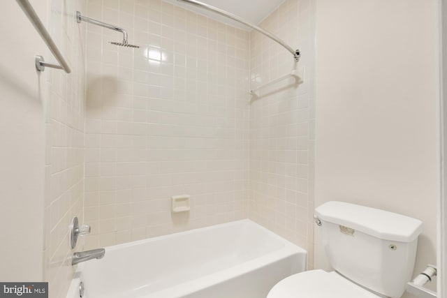 bathroom featuring tiled shower / bath combo and toilet