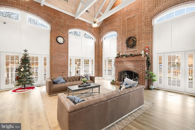 living room with a fireplace, a high ceiling, and beam ceiling