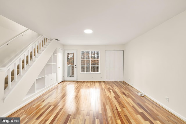 interior space featuring built in shelves and hardwood / wood-style floors