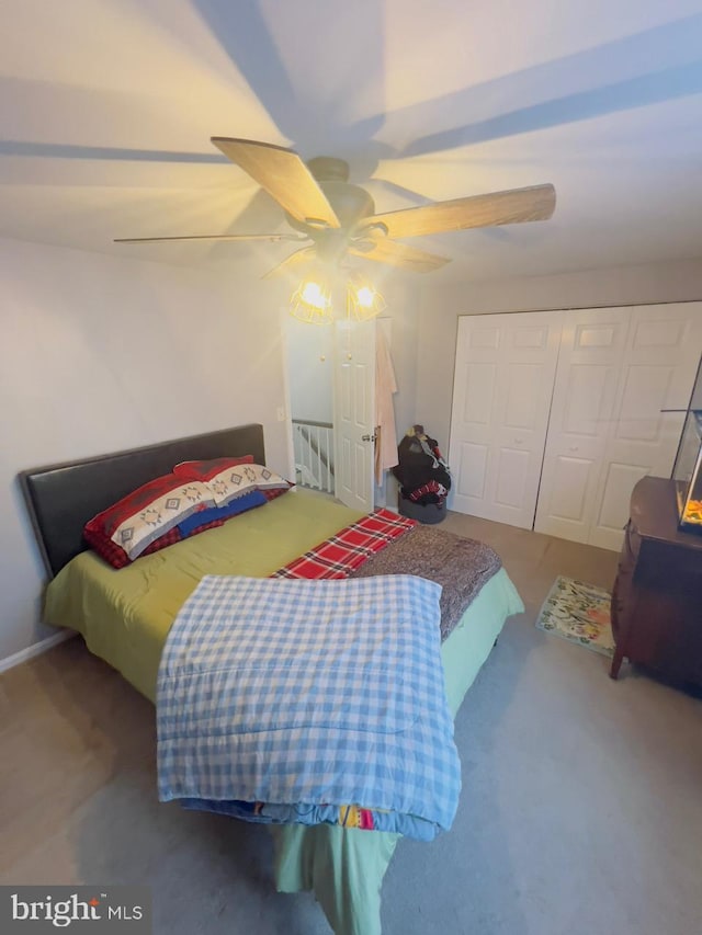 carpeted bedroom with ceiling fan and a closet