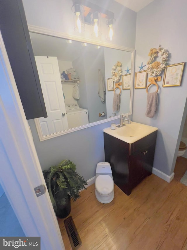 bathroom featuring washer / clothes dryer, vanity, and hardwood / wood-style flooring