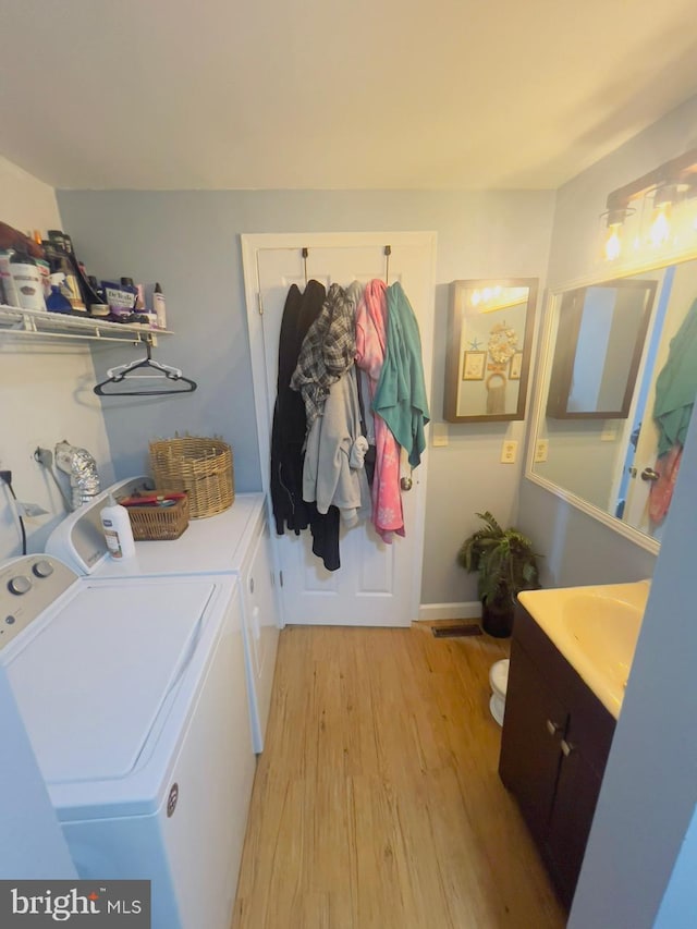 laundry room with light hardwood / wood-style floors and washer and dryer