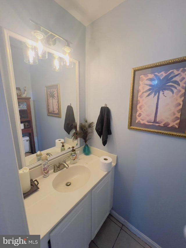 bathroom with a chandelier, vanity, and tile patterned flooring