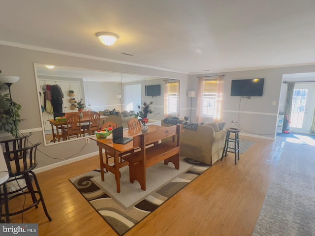 dining area featuring plenty of natural light, light wood-type flooring, and crown molding