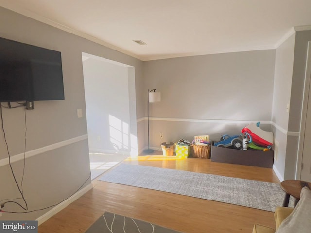 interior space with hardwood / wood-style flooring and ornamental molding