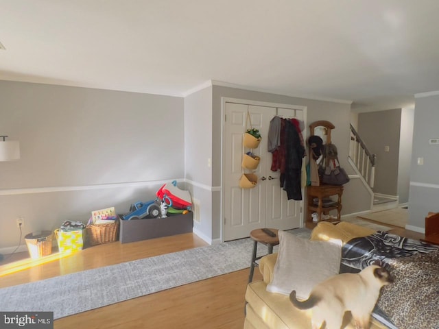 foyer entrance with ornamental molding and wood-type flooring