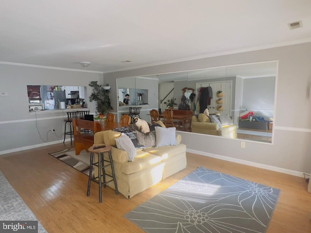 living room with light wood-type flooring and crown molding