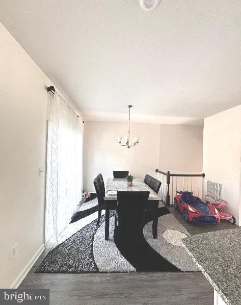 dining space with a chandelier and wood-type flooring