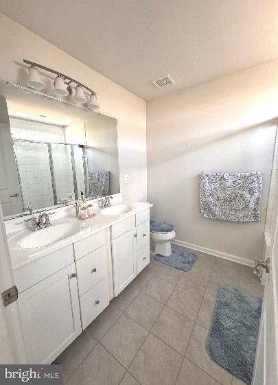 bathroom with vanity, an enclosed shower, toilet, and tile patterned flooring