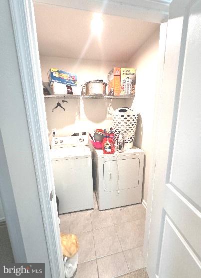 laundry room with washer and dryer and light tile patterned flooring