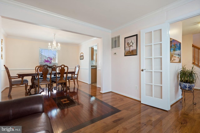 dining area featuring dark hardwood / wood-style flooring, a notable chandelier, and ornamental molding