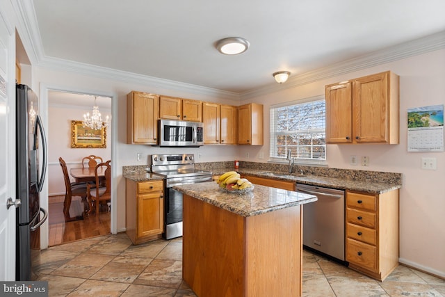 kitchen with dark stone counters, sink, crown molding, a kitchen island, and appliances with stainless steel finishes