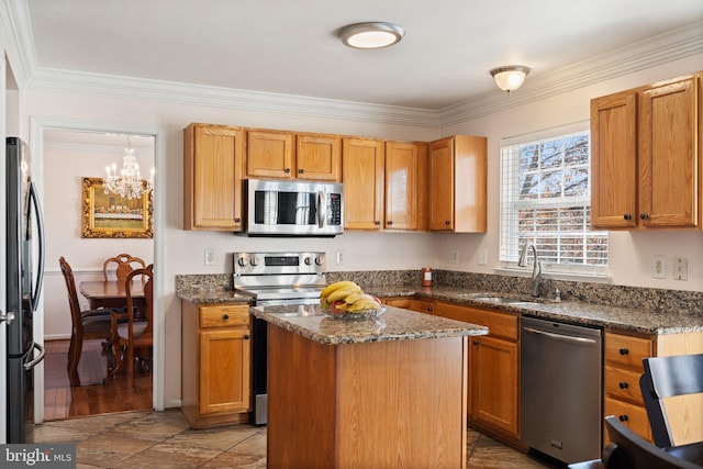 kitchen featuring a center island, a chandelier, ornamental molding, appliances with stainless steel finishes, and dark stone countertops