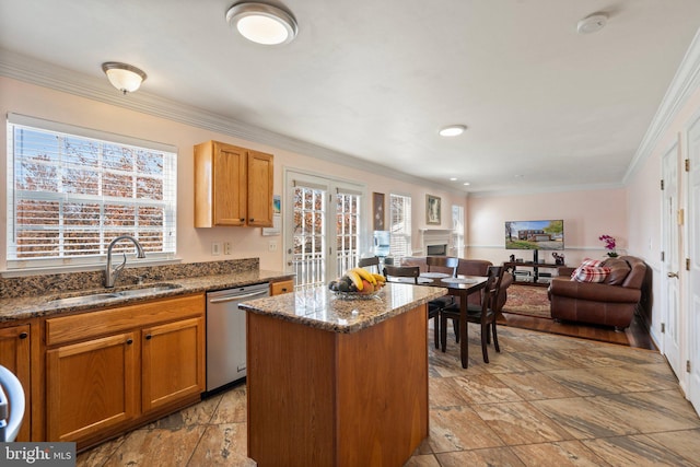 kitchen featuring ornamental molding, a wealth of natural light, stainless steel dishwasher, and a center island