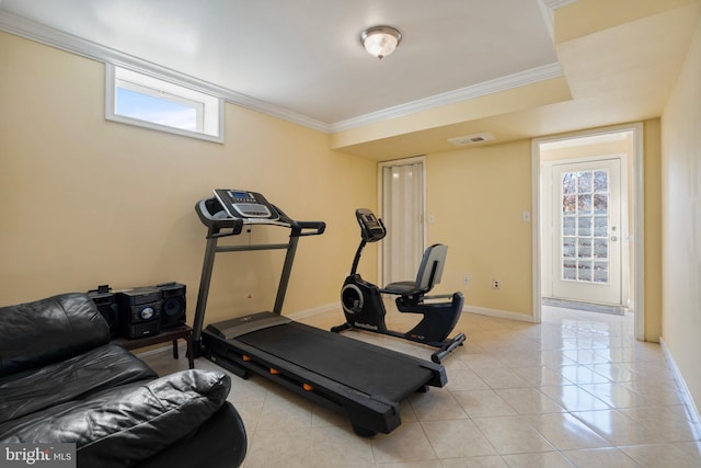 exercise area featuring light tile patterned floors and crown molding