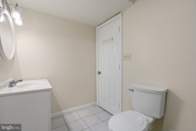 bathroom with toilet, vanity, and tile patterned flooring