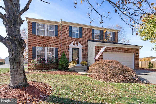 colonial home featuring a front lawn and a garage