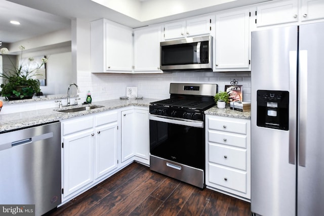 kitchen with appliances with stainless steel finishes, white cabinets, sink, and dark hardwood / wood-style flooring