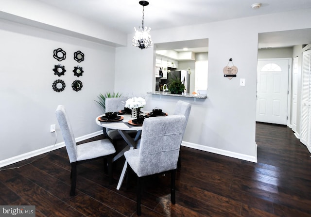 dining space with sink, a chandelier, and dark hardwood / wood-style flooring