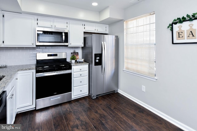 1140 1st St NW, Washington, DC 20001 - kitchen featuring light stone counters, white cabinets, appliances with stainless steel finishes, and decorative backsplash