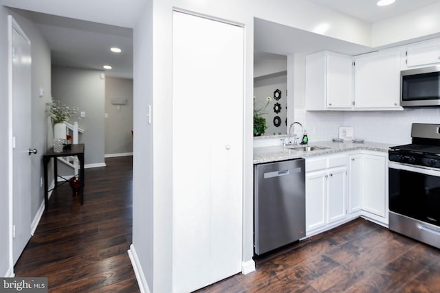 kitchen with white cabinets, stainless steel appliances, sink, and dark hardwood / wood-style flooring