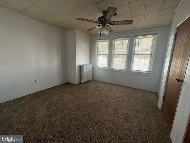 carpeted empty room featuring radiator and ceiling fan