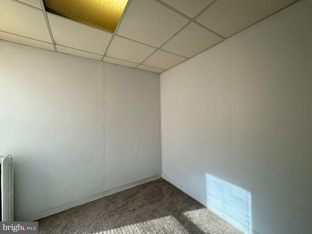 interior space with a drop ceiling, radiator, and carpet flooring