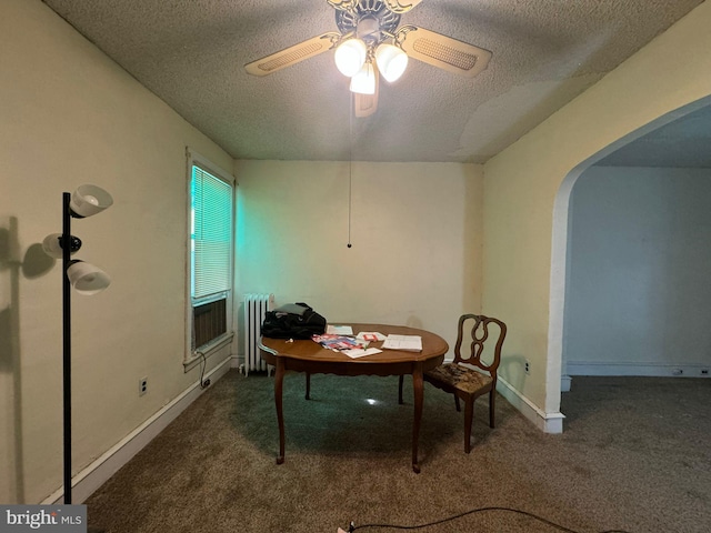 dining space featuring dark colored carpet, ceiling fan, a textured ceiling, and radiator