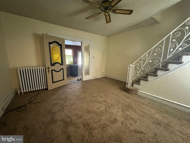 entrance foyer with radiator, ceiling fan, carpet flooring, and a textured ceiling