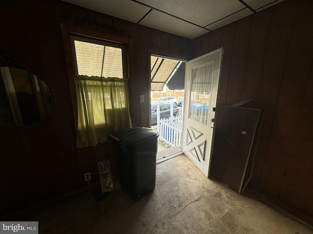 doorway featuring wood walls and carpet