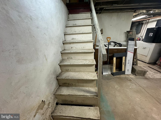 stairway with washer / dryer and concrete floors