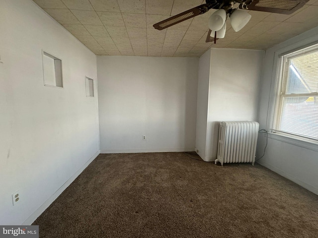 spare room featuring radiator, ceiling fan, and carpet flooring