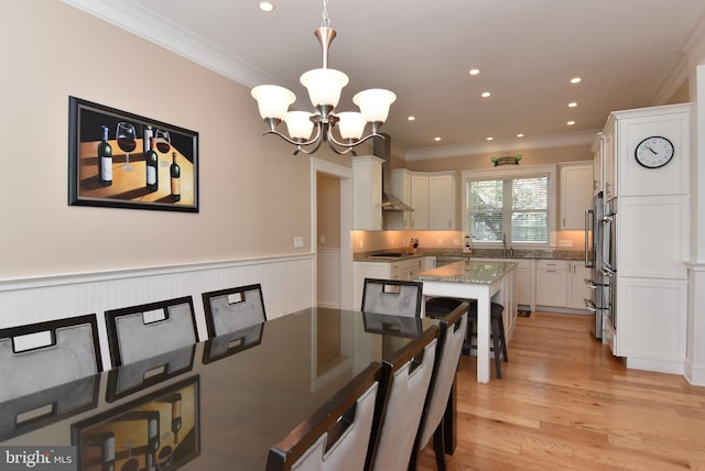 dining room featuring light hardwood / wood-style floors, a chandelier, and crown molding