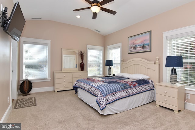 carpeted bedroom with ceiling fan, multiple windows, and lofted ceiling