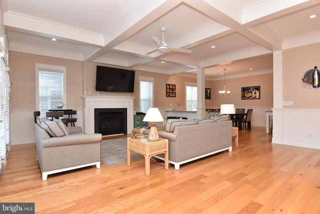 living room featuring light wood-type flooring, plenty of natural light, beam ceiling, and coffered ceiling