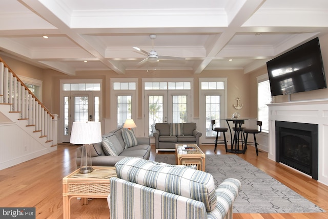 living room featuring light hardwood / wood-style floors, beam ceiling, and coffered ceiling