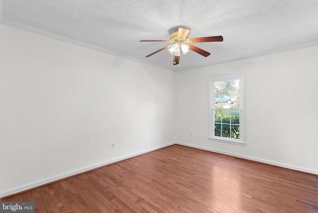 empty room with ceiling fan, crown molding, wood-type flooring, and a textured ceiling