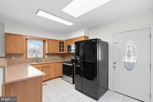 kitchen with crown molding, sink, light stone countertops, light tile patterned floors, and appliances with stainless steel finishes