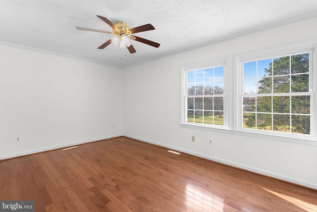 empty room with ceiling fan, crown molding, a textured ceiling, and hardwood / wood-style flooring